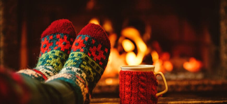 Feet,In,Woollen,Socks,By,The,Christmas,Fireplace.,Woman,Relaxes