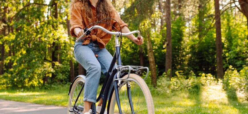 A woman riding a bike along an outdoor trail