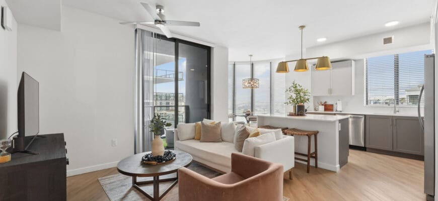 Interior apartment at Evo St. Pete with wood-style flooring, a kitchen with stainless steel appliances, and a private patio